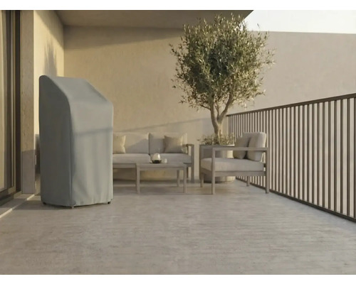 Helle, moderne Terrasse mit einer grauen Abdeckhaube für Gartengeräte, Loungemöbeln aus Metall und einem Olivenbaum im Topf.