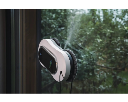 LifenaXX Fensterreinigungsroboter reinigt eine Fensterscheibe mit integrierter Sprühfunktion vor einem Gartenhintergrund.