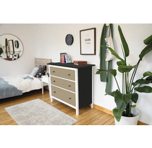 Moderne Kommode mit drei Schubladen in Wiener Geflecht Optik, weißem Rahmen und schwarzer Oberplatte in einem hellen Schlafzimmer.