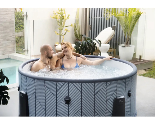 Aufblasbarer Whirlpool mit geometrischem Muster auf einer hellen Terrasse mit Pflanzen und einem Paar.
