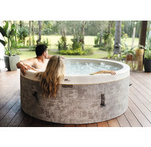 MSpa aufblasbarer Whirlpool mit zwei Personen auf einer Holzterrasse in einem hellen Garten.