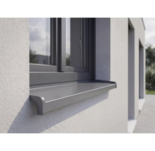 Außenfensterbank aus Aluminium montiert an einer verputzten Fassade unter einem Fenster.