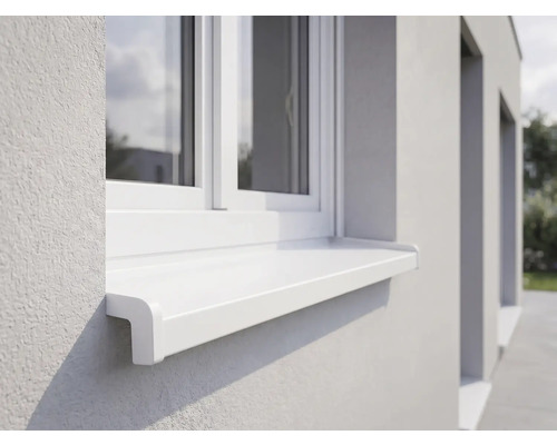 Weiße Außenfensterbank aus Kunststoff an einer hell verputzten Fassade unter einem weißen Fenster.