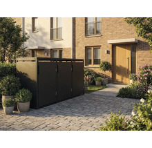 Moderne Mülltonnenbox aus Metall für drei Abfallbehälter in einem gepflasterten Vorgarten vor einem Backsteinhaus mit Pflanzen.