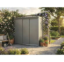 Moderner Geräteschrank aus Metall mit Schiebetüren auf einer Steinterrasse in einem hellen, organisierten Garten mit Blumen und Pflanzen.