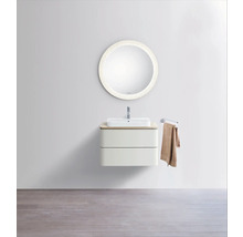 Moderner Waschplatz mit rundem Spiegel, weißem Aufsatzwaschbecken und wandhängendem Unterschrank mit zwei Schubladen in hellem Design.