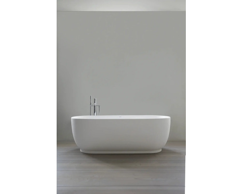 Freistehende, ovale Badewanne in modernem Design mit verchromter Bodenarmatur und Handbrause in einem hellen, minimalistischen Badezimmer.