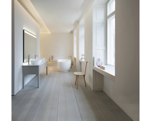 Helles, minimalistisches Badezimmer mit freistehender weißer Badewanne, Doppelwaschtisch mit Aufsatzbecken und hellem Holzboden.