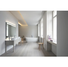 Geräumiges, helles Badezimmer mit Doppelwaschtisch, LED-Spiegel, freistehender Badewanne und hellem Holzboden in modernem, minimalistischem Design.