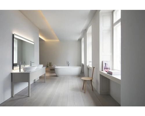 Geräumiges, helles Badezimmer mit Doppelwaschtisch, LED-Spiegel, freistehender Badewanne und hellem Holzboden in modernem, minimalistischem Design.
