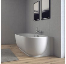 Modernes Badezimmer mit Badewanne, Wandarmatur, Wänden in Betonoptik und Holzboden in einer hellen, minimalistischen Atmosphäre.