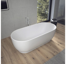 Freistehende ovale Badewanne in einem modernen Badezimmer mit Holzfußboden, Betonwand und bodenstehender Armatur.