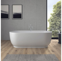 Freistehende Badewanne in einem modernen Badezimmer mit Holzboden, Sichtbetonwand und verchromter Standarmatur.