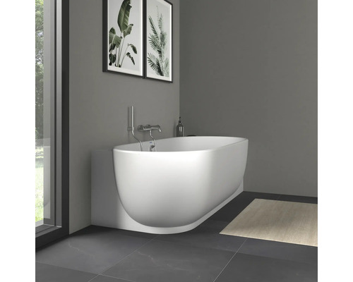 Modernes weißes ovales Wand-Badewannenmodell mit verchromter Armatur in einem minimalistischen Badezimmer mit Fliesenboden und Wanddekoration.