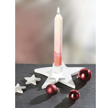 Weihnachtsdekoration mit einem weißen sternförmigen Kerzenhalter, einer brennenden Kerze, kleinen Dekosternen und roten Weihnachtskugeln.