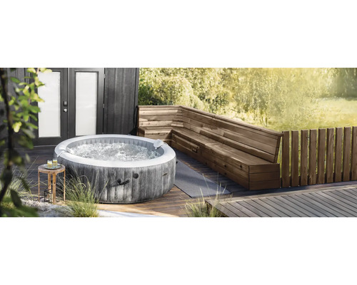 Aufblasbarer Whirlpool von Intex in runder Form mit Holzoptik auf einer Holzterrasse neben einer hölzernen Eckbank.