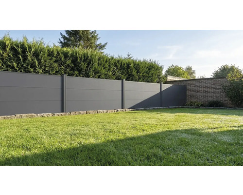 Moderner Sichtschutzzaun aus anthrazitfarbenen horizontalen Paneelen in einem Garten mit Rasenfläche und Hecke.