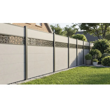 Moderner Sichtschutzzaun aus Paneelen mit geometrischem Dekorelement in einem Garten mit Rasen.