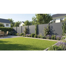 Moderner Sichtschutzzaun in Anthrazit in einem Garten mit Rasen, Lavendel und Holzmöbeln auf einer Kiesterrasse.