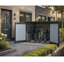 Moderne Fahrradbox aus Metall mit geöffneten Doppeltüren und vier Fahrrädern vor einem Hauseingang mit Ziegelwand, wirkt organisiert.