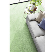 Moderner grüner Teppichboden in einem hellen Wohnzimmer mit grauem Sofa und Beistelltisch.