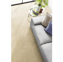 Heller Teppichboden in einem modernen Wohnzimmer mit grauem Sofa und rundem Beistelltisch.