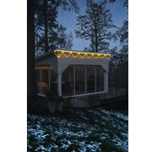 LED-Eisregen-Lichterkette warmweiß an einem modernen Gartenhaus in winterlicher Umgebung bei Nacht.