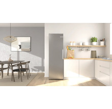Moderne, helle Küche mit freistehendem Edelstahl-Kühlschrank, weißen Schränken mit Holz-Arbeitsplatte und einem angrenzenden Essbereich.