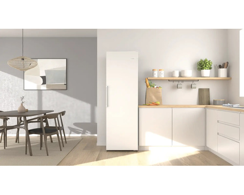 Helle, moderne Küche mit freistehendem weißem Kühlschrank, hölzernen Arbeitsplatten, weißen Schränken und Essbereich mit Holzmöbeln.