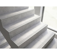 Treppe mit Fliesen in Steinoptik und Sicherheitsrillen an den Stufenkanten.