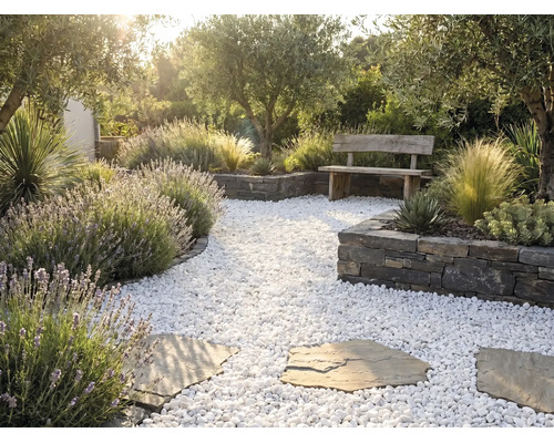 Heller mediterraner Garten mit weißem Kiesweg, Trittsteinen, Trockenmauern, Holzbank, Lavendel und Olivenbäumen.