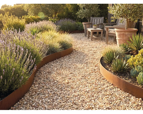 Gartenweg aus Kies mit geschwungener Beetbegrenzung aus Metall in Edelrost-Optik, bepflanzt mit Lavendel, Ziergräsern und Sukkulenten.