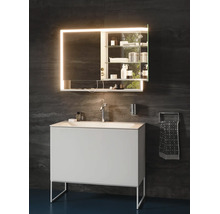 Modernes Badezimmer mit weißem Waschtisch, Chromarmatur und beleuchtetem Spiegelschrank vor dunkler Wand.