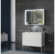 Modernes Badezimmer mit weißem Waschtischunterschrank auf Metallgestell, Waschbecken mit Chromarmatur und LED-Spiegelschrank vor dunklen Wänden.