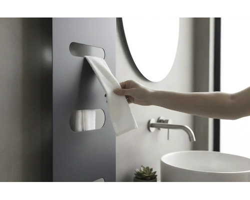 Moderner, dunkelgrauer Handtuchheizkörper mit Aussparungen für Handtücher in einem hellen Badezimmer mit Waschbecken und Spiegel.