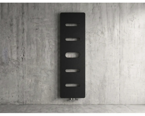 Vertikaler Design Heizkörper in Schwarz mit ovalen Aussparungen an einer Betonwand.