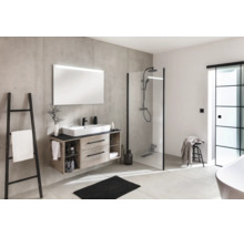 Modernes Badezimmer mit Waschtisch in Holzoptik, großem Spiegel, begehbarer Dusche mit schwarzem Rahmen und Wänden in Betonoptik.