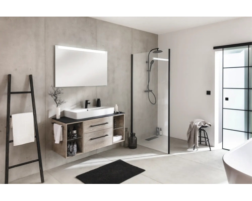 Modernes Badezimmer mit Waschtisch in Holzoptik, großem Spiegel, begehbarer Dusche mit schwarzem Rahmen und Wänden in Betonoptik.