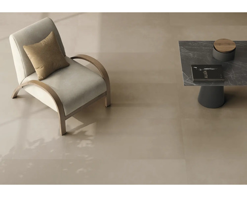Großformatige, glatte Bodenfliesen in hellem Beige in einem modernen Wohnzimmer mit Sessel und Beistelltisch.