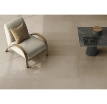 Großformatige, glatte Bodenfliesen in hellem Beige in einem modernen Wohnzimmer mit Sessel und Beistelltisch.