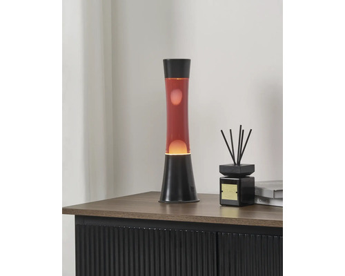 Lavalampe mit roter Flüssigkeit und schwarzem Sockel auf einem Sideboard neben einem Raumdiffuser.