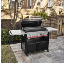 Weber Slate Gasgrill mit drei Brennern, Deckel und Seitenablagen auf einer gepflasterten Terrasse.
