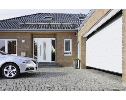 Einfamilienhaus mit Haustür, Garagentor und gepflasterter Einfahrt