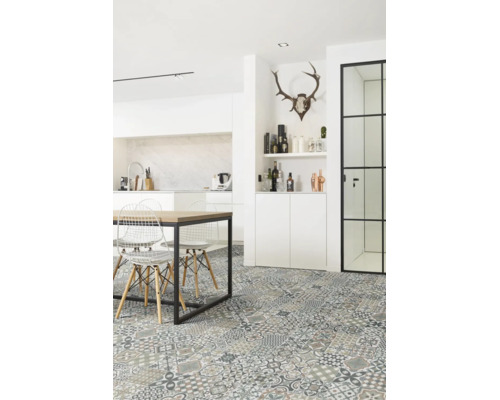 Helle moderne Küche mit gemusterten Bodenfliesen im Patchwork-Design, Holztisch mit schwarzem Metallgestell und weißen Drahtstühlen.