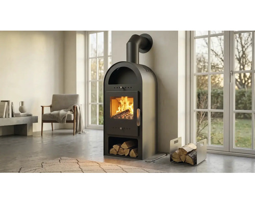 Schwarzer Kaminofen mit Rundbogen, integriertem Holzfach und brennendem Feuer in einem hellen, modernen Wohnzimmer mit großen Fenstern.