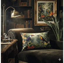 Dunkler Sessel mit dekorativem Kissen mit Tukan-Motiv in einem klassisch eingerichteten Zimmer mit Bücherregal und Messing-Schreibtischlampe.