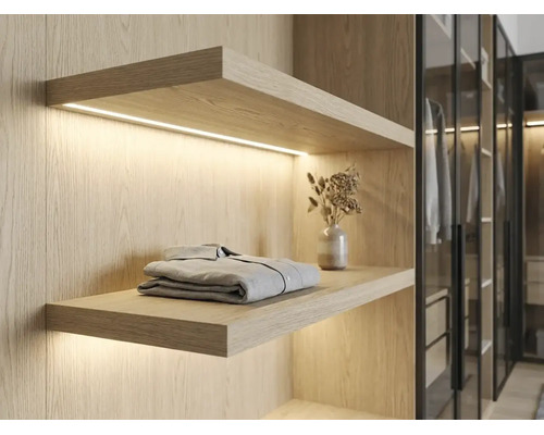 Wandregal aus hellem Holz mit integrierter LED-Beleuchtung im begehbaren Kleiderschrank, modernes Design.