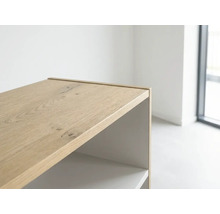 Detailansicht eines Möbels mit Oberfläche in heller Holzoptik und passender Abschlussleiste in einem hellen Raum.