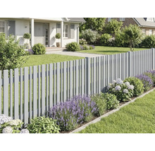 Moderner grauer Lattenzaun in einem gepflegten Garten mit Lavendel, Hortensien und Rasen vor einem Haus.