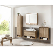Helles, organisiertes Badezimmer mit Möbeln in Eichenoptik, weißem Aufsatzwaschbecken, Spiegelschrank, Hochschrank und Beistellschrank.